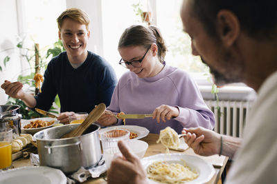 Happy family enjoying food together on dining table at home