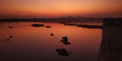 Scenic view of river mahanadi against romantic sky at sunset