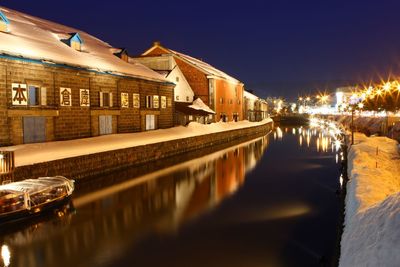 Canal amidst buildings against sky at night