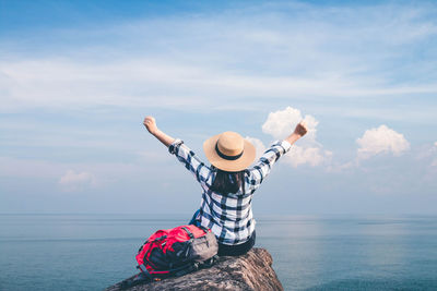 Man wearing hat in sea against sky