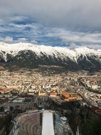 Aerial view of cityscape against snowcapped mountains