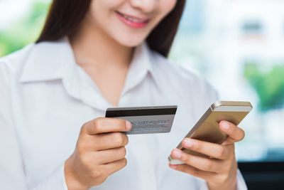 Midsection of woman using mobile phone