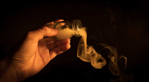 Close-up of hand holding burning candle