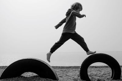 Low angle view of man jumping against sky