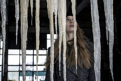 Portrait of woman standing against window