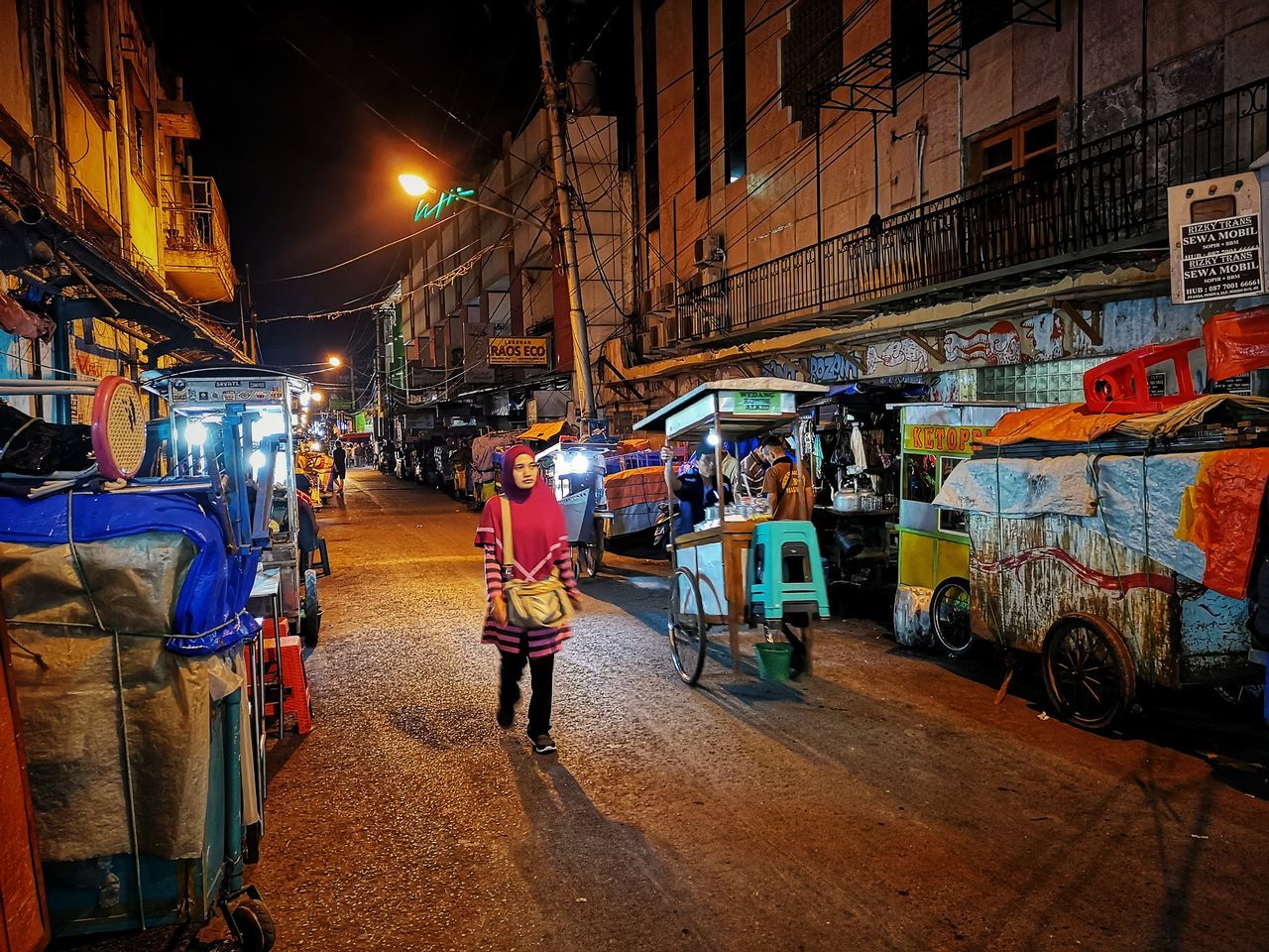 transportation, real people, street, mode of transportation, city, illuminated, night, land vehicle, architecture, market, built structure, men, people, lifestyles, building exterior, market stall, road, city life, motor vehicle, street market