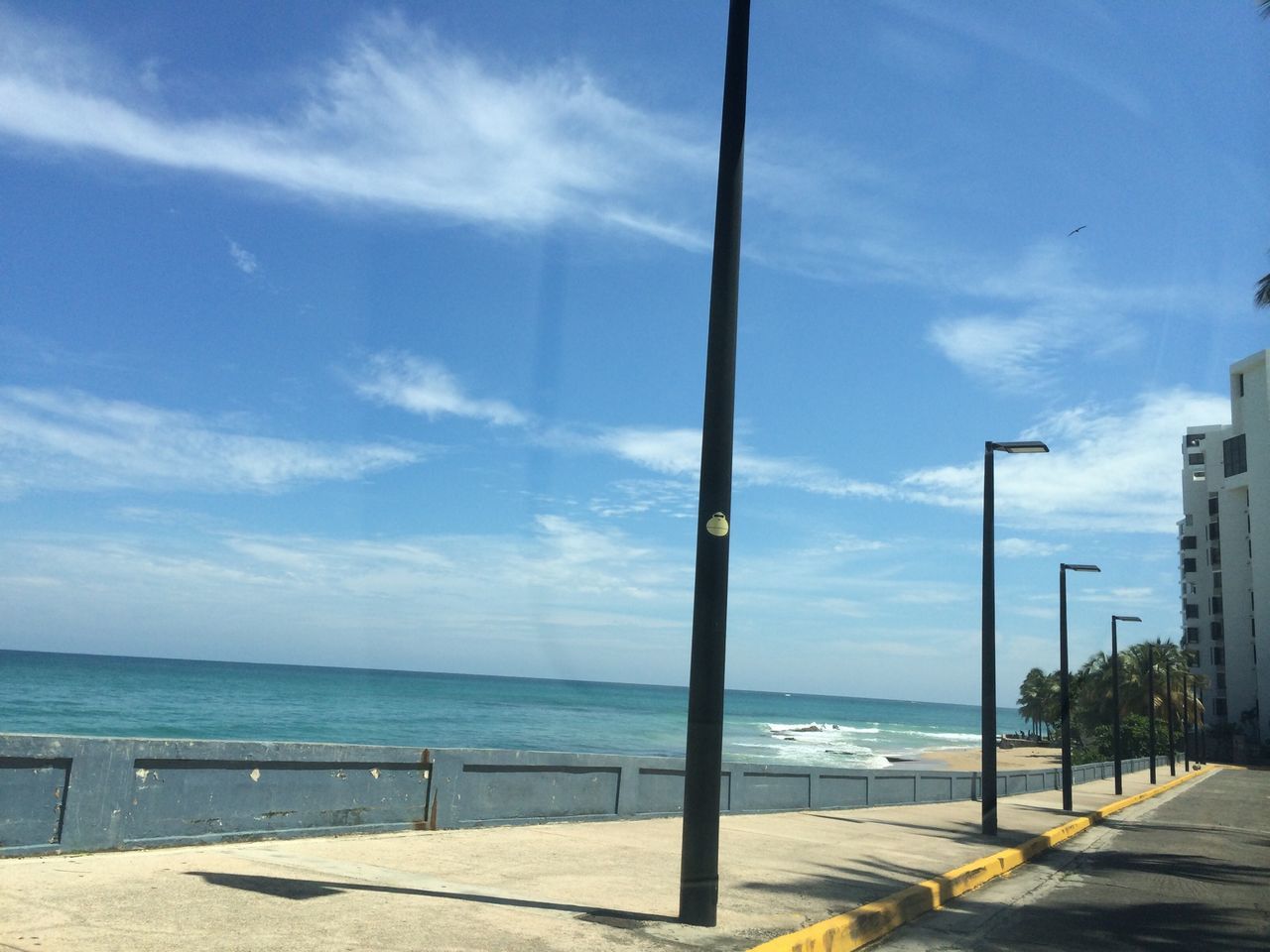 sea, water, horizon over water, sky, beach, shore, tranquility, scenics, tranquil scene, beauty in nature, nature, blue, cloud - sky, street light, incidental people, railing, sand, cloud, idyllic, sunlight