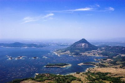 Aerial view of city by sea against sky