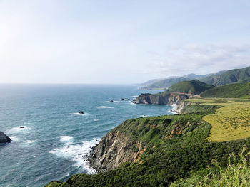 Scenic view of cliffs by the sea against sky