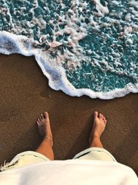 Low section of woman standing at beach