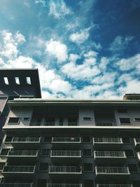 Low angle view of modern building against cloudy sky