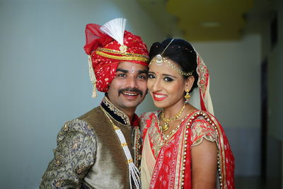 Smiling young couple standing against wall