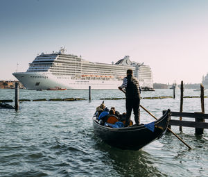 People on boat in sea against clear sky