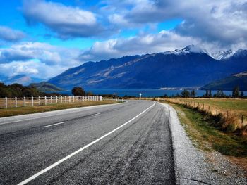 Road by mountains against sky