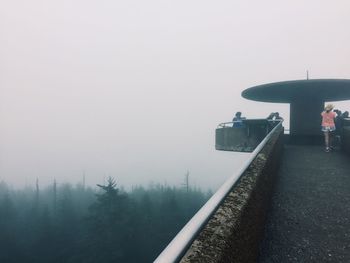 Man standing on snow covered landscape in foggy weather