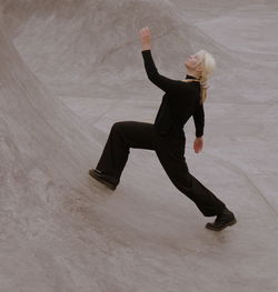 Woman in black performing on the gray concrete pool