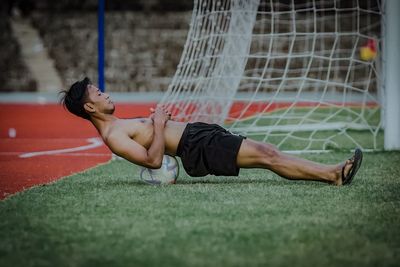 Full length of woman exercising on field