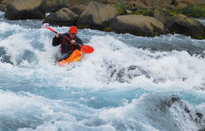 Man going on his white water kayak rapids in an icelandic river