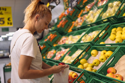 Side view of man holding fruits at market