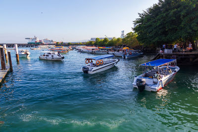 Boats moored in sea against clear sky