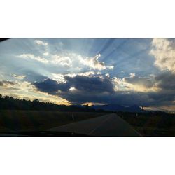 Scenic view of field against cloudy sky