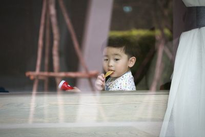 Cute boy eating food while sitting at home