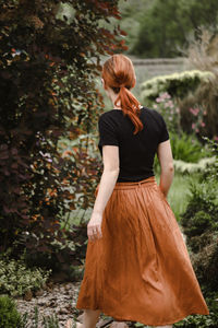 Happy ginger hair woman walking barefoot in the park or garden. freedom and healthy way of life