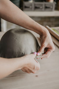 Close up of young woman hands molding clay in small studio shop