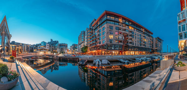 Illuminated buildings in city against sky