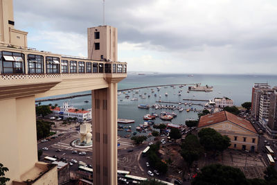 High angle view of city by sea against sky