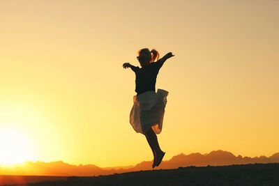 Full length of silhouette man standing at sunset