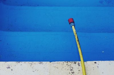 Close-up of pipe against blue wall