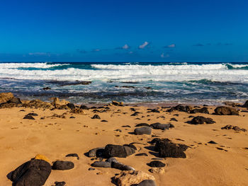 Scenic view of beach against blue sky