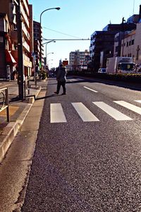 Rear view of men walking on road in city