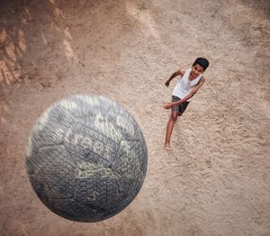 High angle view of boy playing with soccer ball