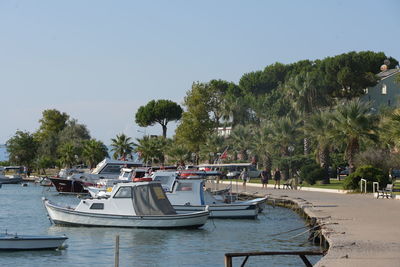 Boats moored in sea against clear sky