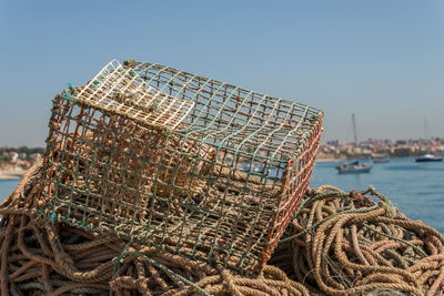 Fishing net at harbor against clear sky