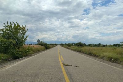 Road amidst trees against sky