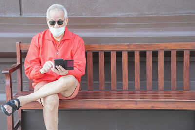 Portrait of man sitting on railing