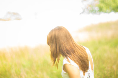 Rear view of woman standing on field