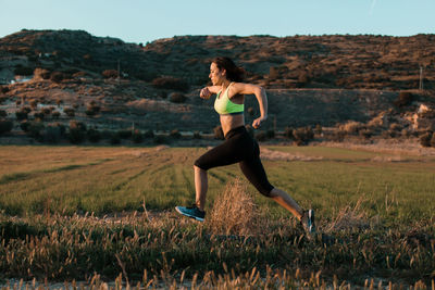 Full length of woman running on grass