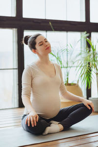 Portrait of young woman sitting at home