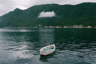 Boat floating on lake against mountains