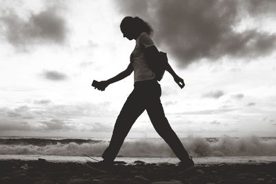 Full length of silhouette woman standing on land against sky