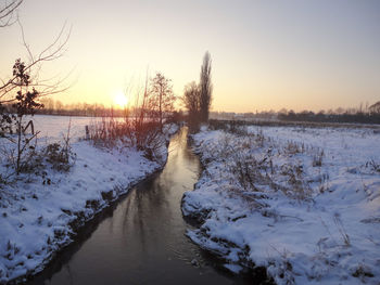 Scenic view of snow covered landscape during sunset