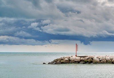 Lighthouse by sea against sky