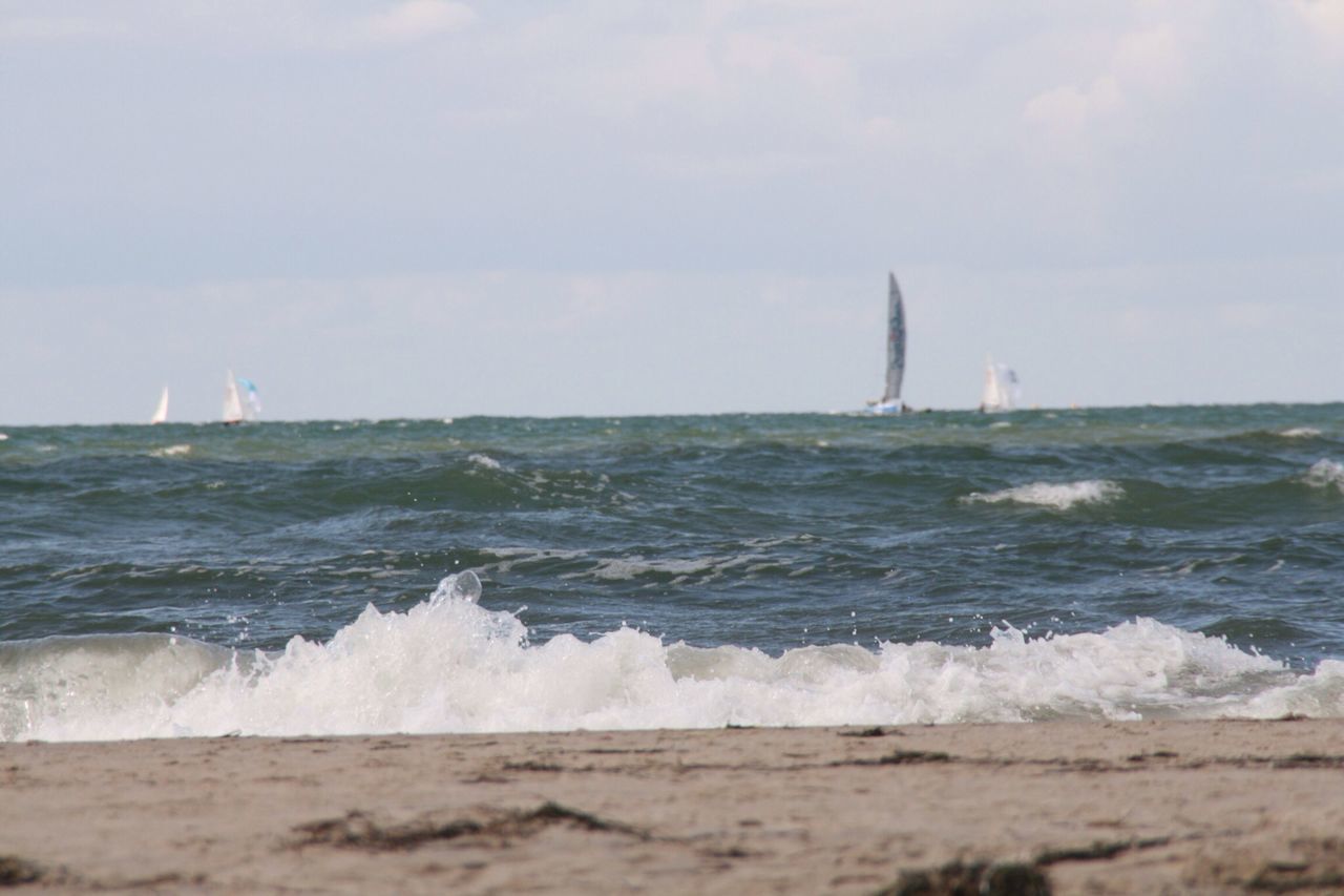 sea, water, horizon over water, wave, surf, lighthouse, sky, beach, built structure, scenics, guidance, beauty in nature, building exterior, nature, architecture, motion, shore, waterfront, travel destinations, direction