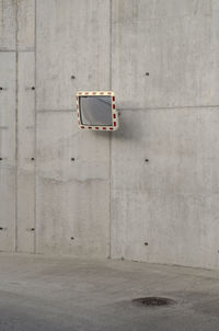 Road mirror on concrete wall