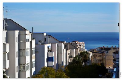High angle view of buildings and sea against sky
