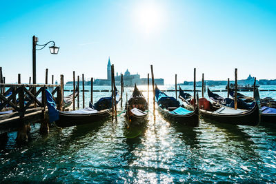 High angle view of gondolas moored in canal against clear blue sky